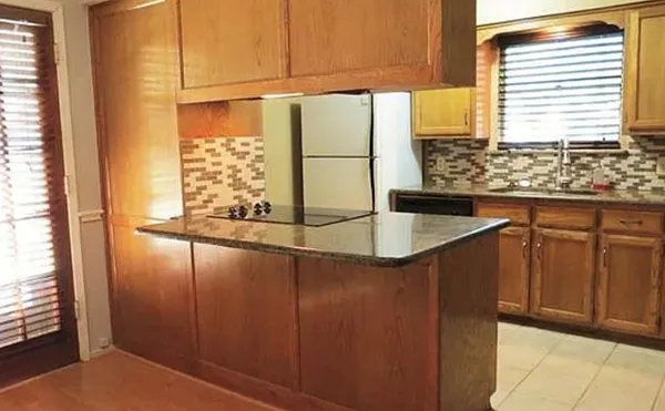 a kitchen with stainless steel appliances granite countertop a sink and a refrigerator