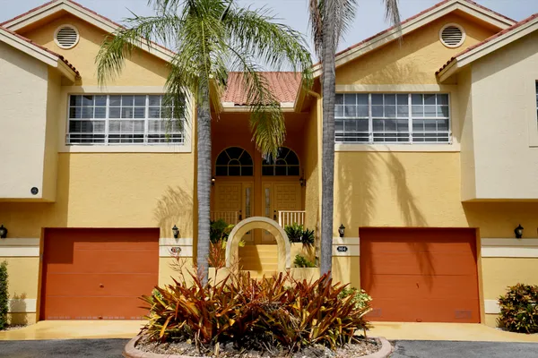 a front view of a house with plants