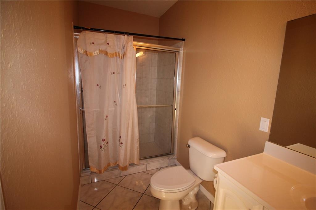 168 Southwest Ridgecrest Drive Port St. Lucie, FL 34953 - Photo 11 of 17 a white toilet sitting next to a bathroom sink