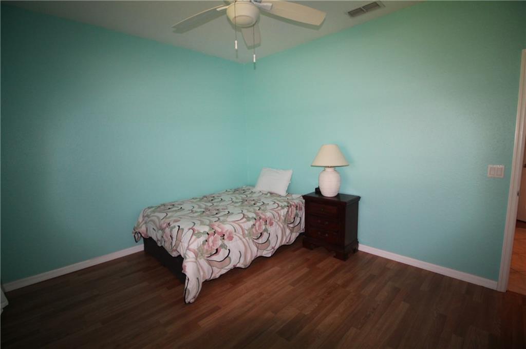 168 Southwest Ridgecrest Drive Port St. Lucie, FL 34953 - Photo 14 of 17 a bedroom with a bed and wooden floor