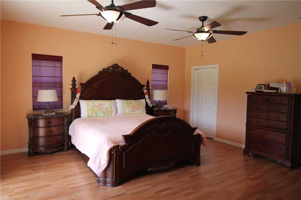 168 Southwest Ridgecrest Drive Port St. Lucie, FL 34953 - Photo 7 of 17 a bedroom with a bed and wooden floor