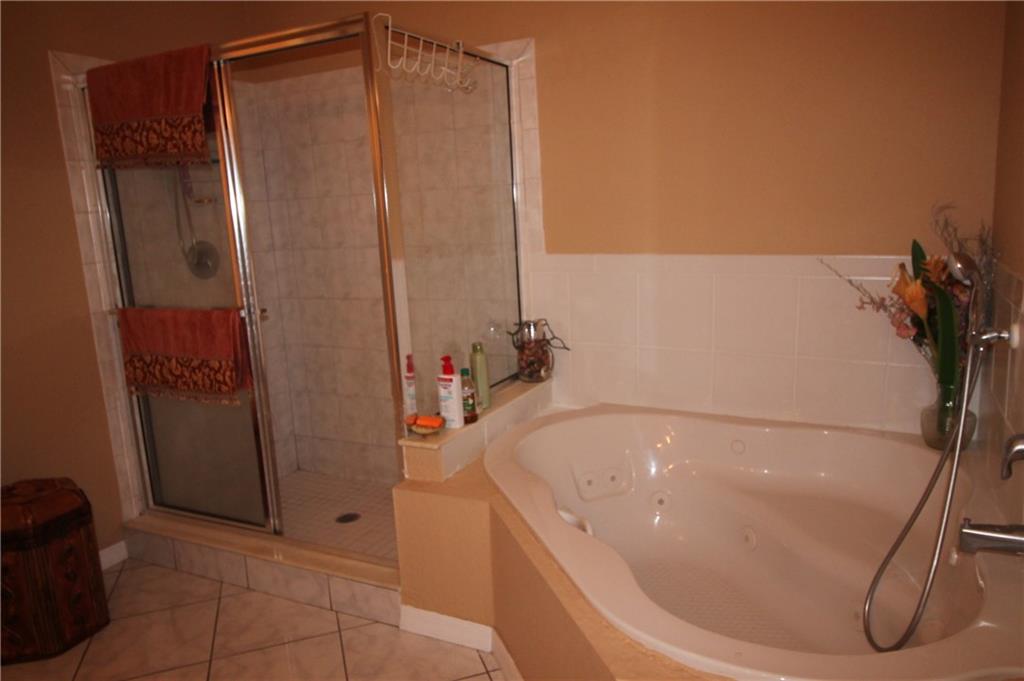 168 Southwest Ridgecrest Drive Port St. Lucie, FL 34953 - Photo 9 of 17 a bathroom with a tub and a shower