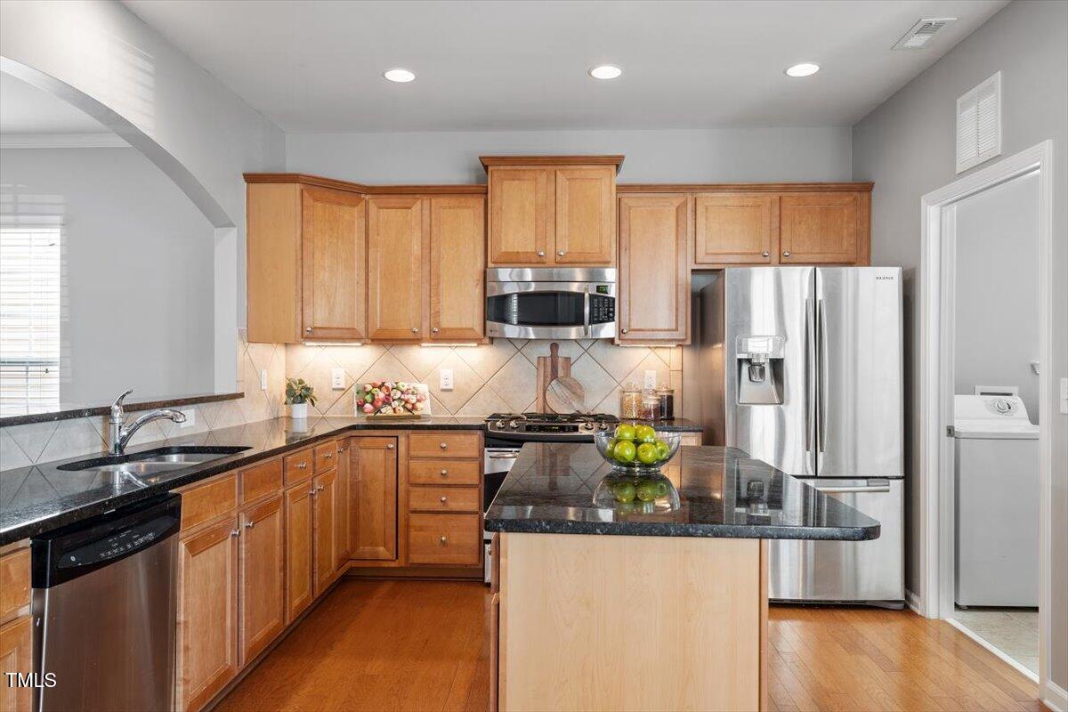 812 Gillinder Place Cary, NC 27519 - Photo 12 of 59 a kitchen with granite countertop stainless steel appliances a refrigerator and a sink