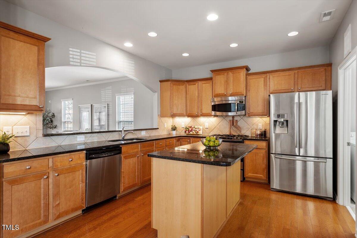 812 Gillinder Place Cary, NC 27519 - Photo 13 of 59 a kitchen with wooden cabinets and stainless steel appliances