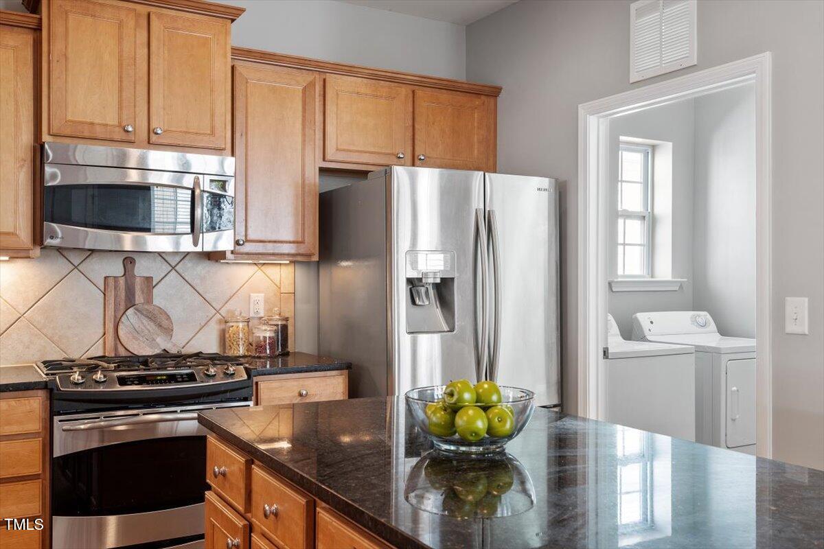 812 Gillinder Place Cary, NC 27519 - Photo 15 of 59 a kitchen with stainless steel appliances a stove a refrigerator and a cabinets