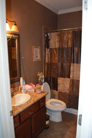 a bathroom with a granite countertop sink toilet a mirror and shower
