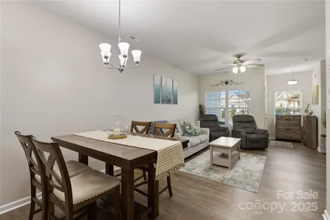 a view of a dining room with furniture a chandelier and wooden floor