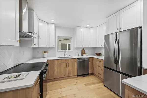 a kitchen with stainless steel appliances granite countertop a refrigerator sink and white cabinets