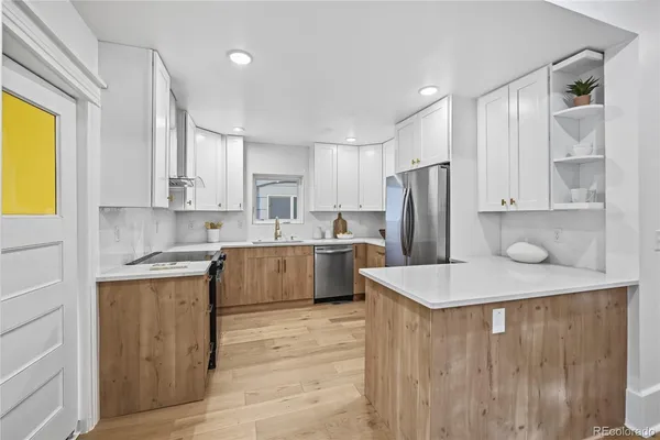 a kitchen with a sink a refrigerator and cabinets