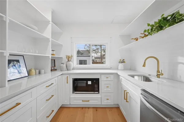 a kitchen with white cabinets and appliances