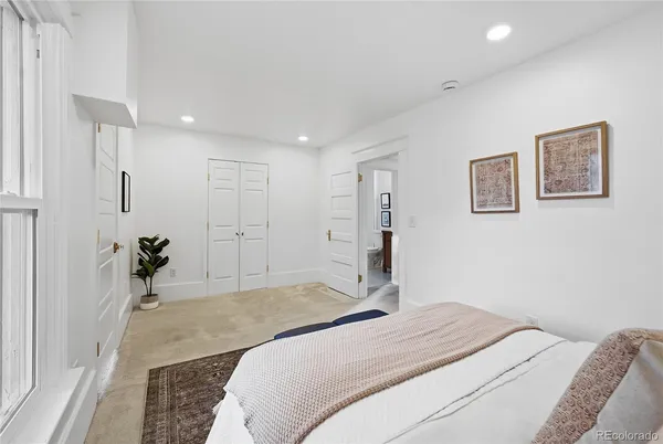 a bedroom with a large bed and a chandelier