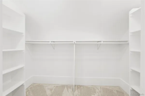a view of walk in closet with empty racks