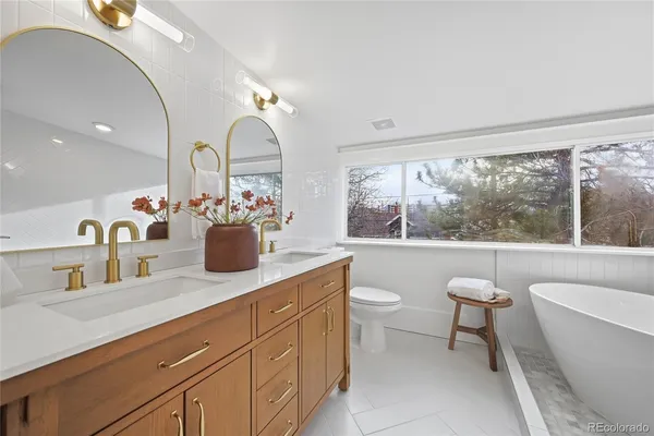 a bathroom with a granite countertop sink mirror and bathtub