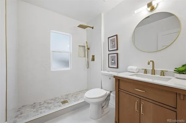 a bathroom with a toilet a sink a mirror and vanity