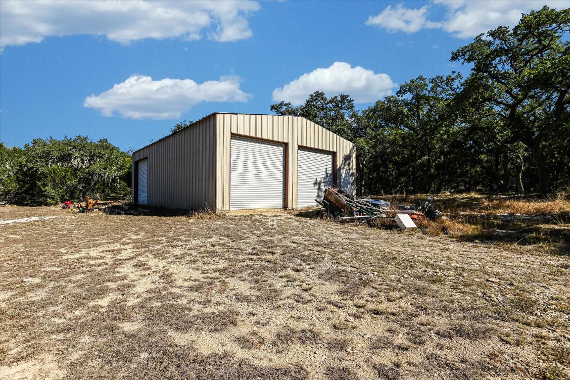 5300 Fischer Store Road Wimberley, TX 78676 - Photo 13 of 20 a backyard of a house with table and chairs under an umbrella