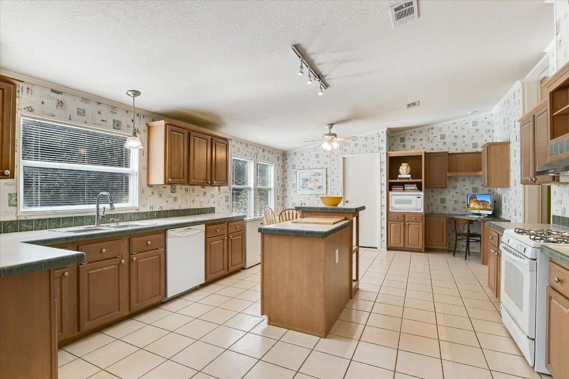 5300 Fischer Store Road Wimberley, TX 78676 - Photo 6 of 20 a large kitchen with cabinets a sink a counter top space and stainless steel appliances