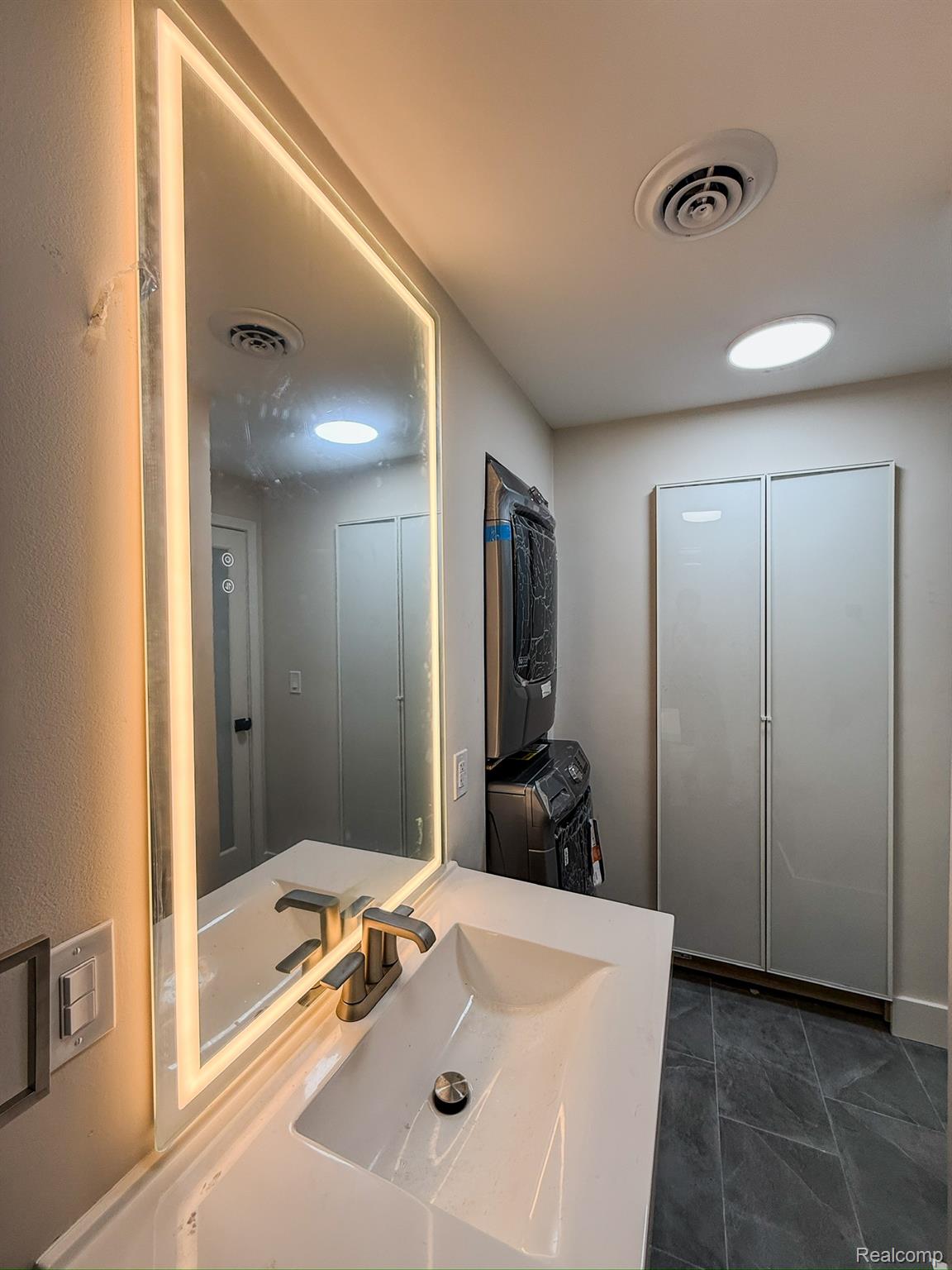 30052 Schoenherr Road Warren, MI 48088 - Photo 26 of 38 Vanity featuring an integrated sink, brushed nickel faucet, and an illuminated mirror