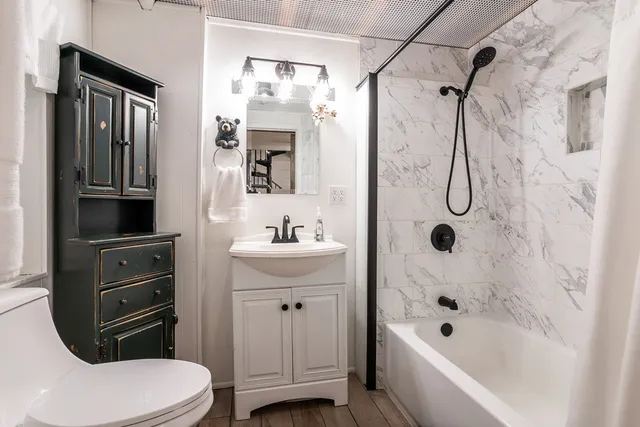 a bathroom with a sink a toilet and shower