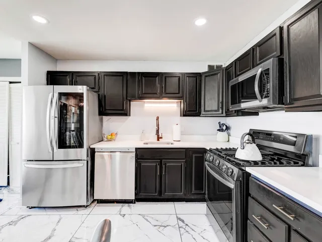a kitchen with stainless steel appliances a refrigerator stove and microwave