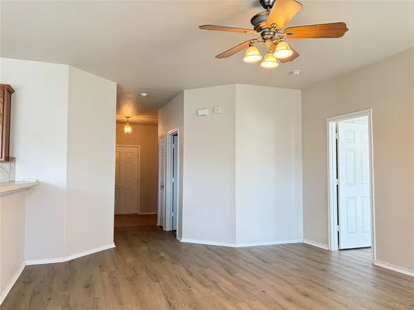 a view of an empty room with window and wooden floor