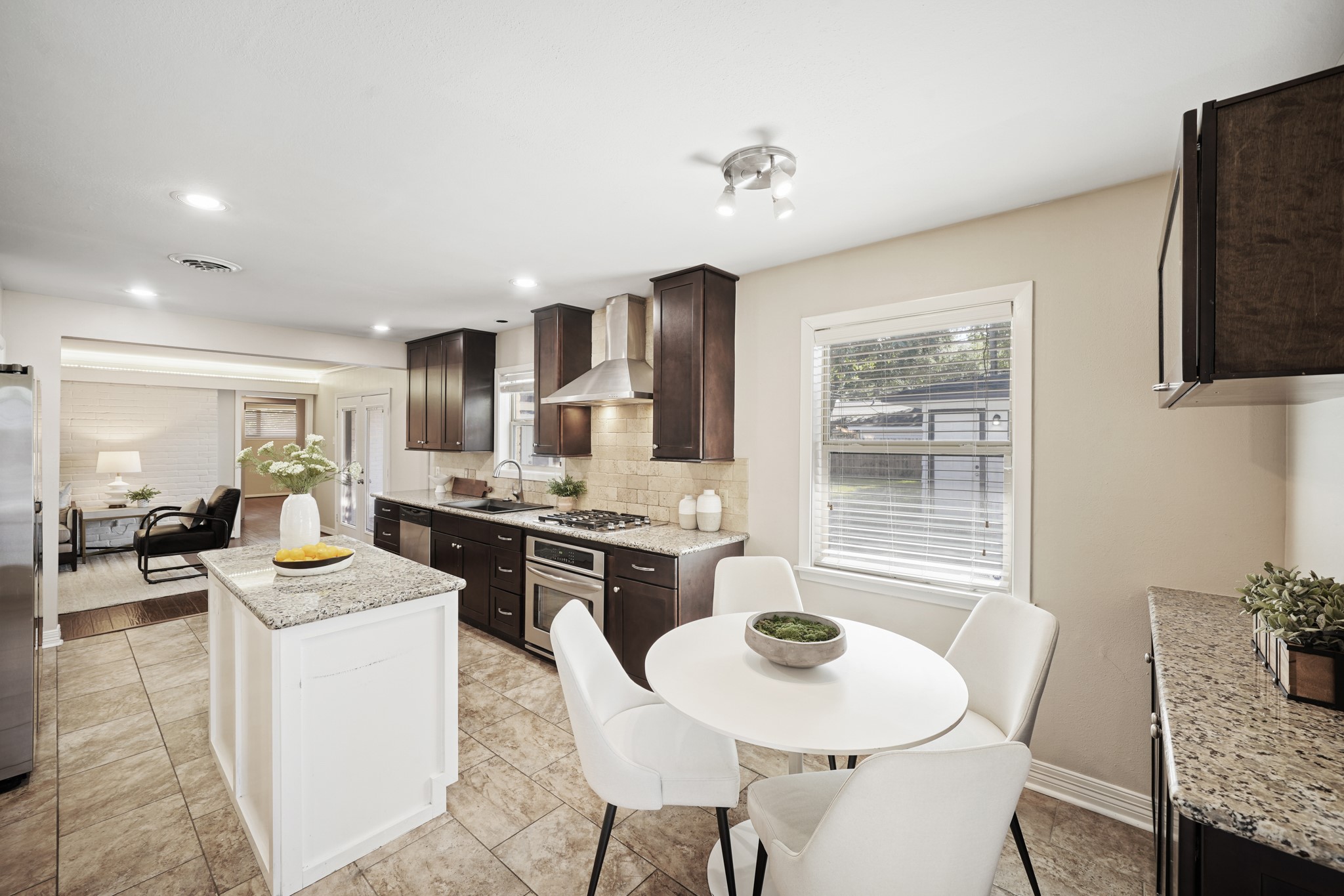 5671 Sylmar Road Houston, TX 77081 - Photo 16 of 50 a kitchen with sink refrigerator dining table and chairs