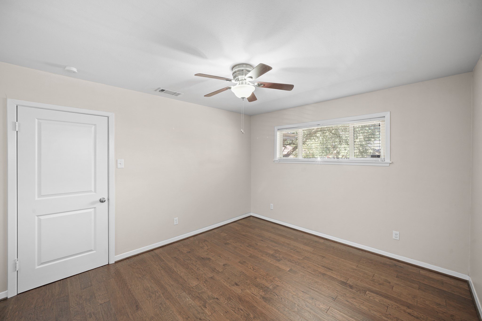 5671 Sylmar Road Houston, TX 77081 - Photo 28 of 50 a view of a room with wooden floor and a ceiling fan