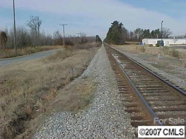 a view of a dry yard with wooden fence