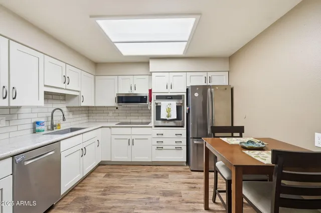 a kitchen with granite countertop a sink appliances cabinets and counter space