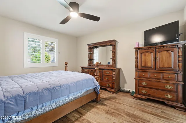 a bedroom with a bed and a flat tv screen on dresser