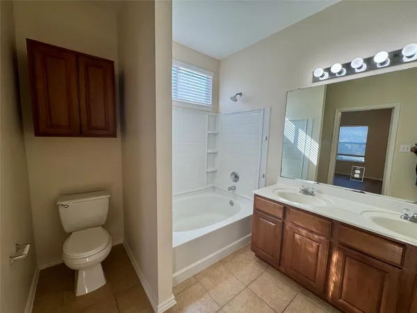 a spacious bathroom with a sink a toilet and bathtub