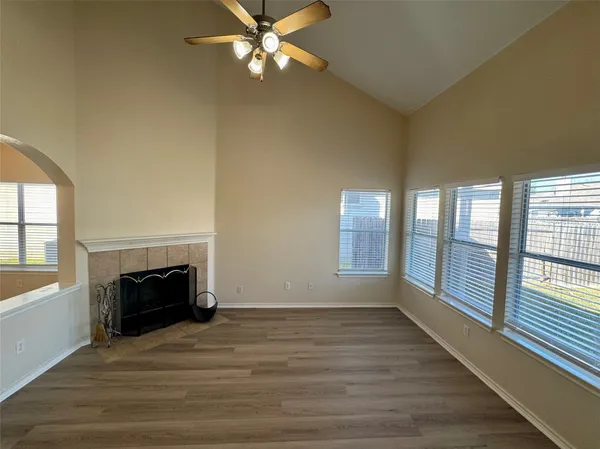 wooden floor fireplace and windows in an empty room