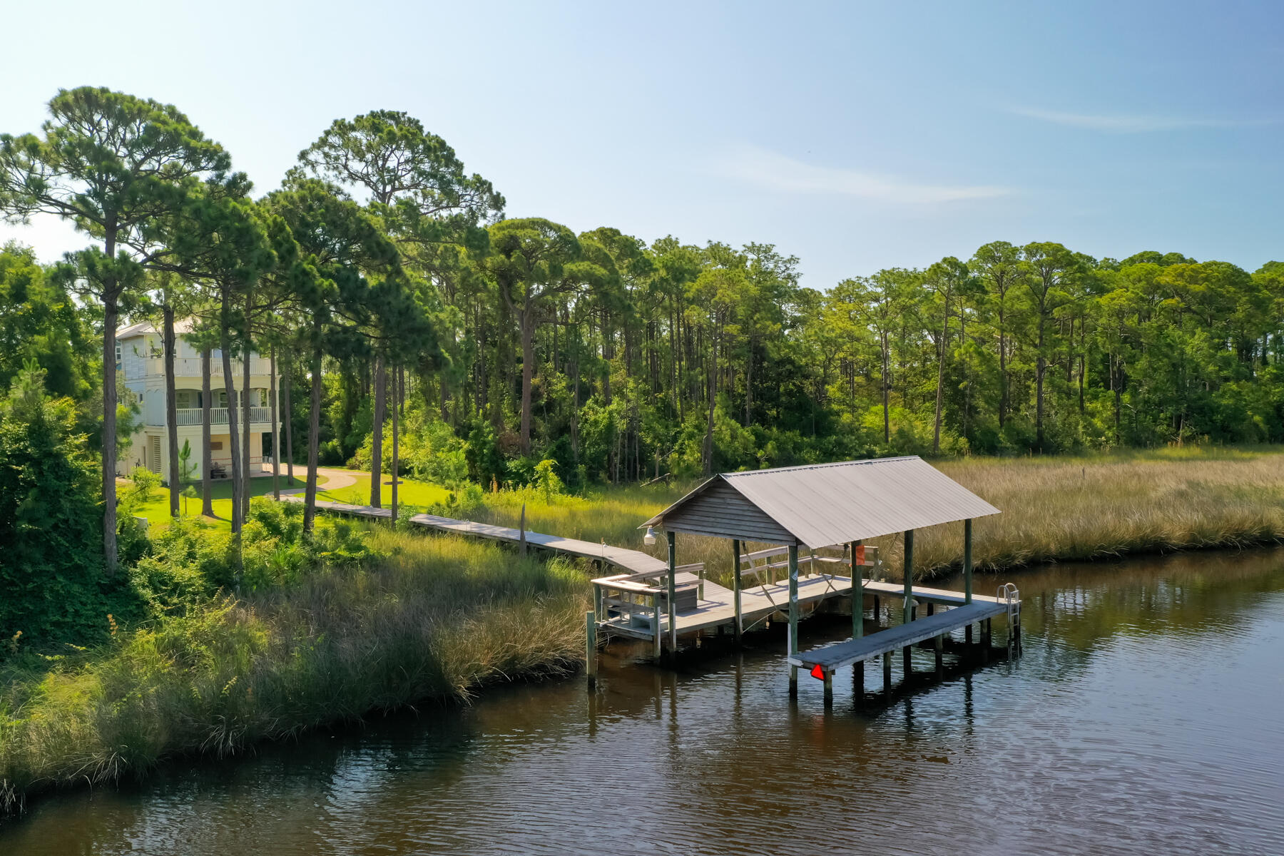 a view of a lake with lawn chairs under an umbrella