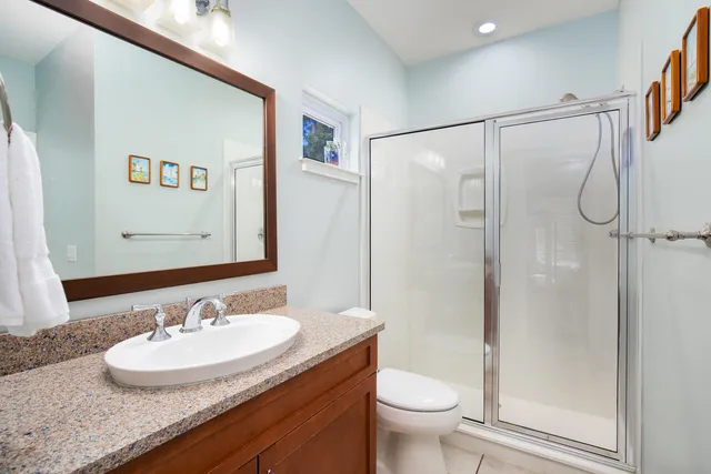 a bathroom with a granite countertop sink toilet and a mirror