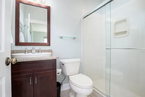 a bathroom with a granite countertop sink toilet and shower