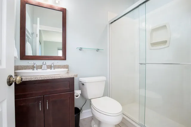a bathroom with a granite countertop sink toilet and shower