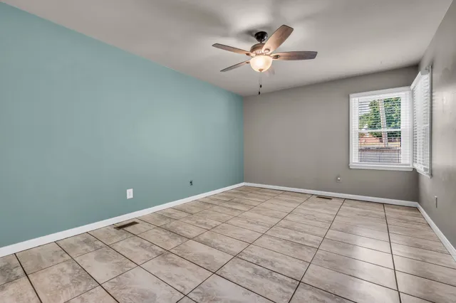 a spacious bedroom with a bed a chandelier and a potted plant
