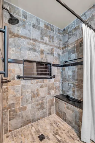 a view of an empty room with window and chandelier fan