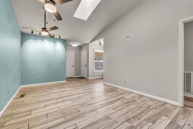 a view of empty room with wooden floor