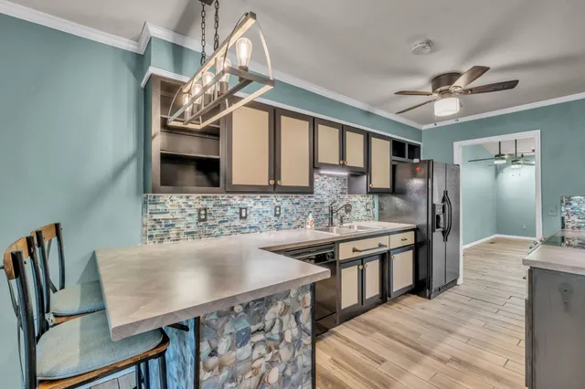 a kitchen with stainless steel appliances granite countertop a sink a stove and chairs