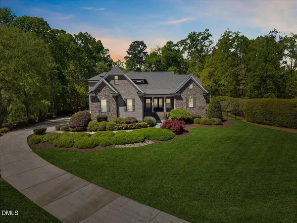 a front view of a house with a yard and trees