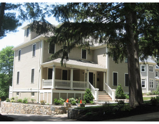 a view of a white house with large windows and a tree
