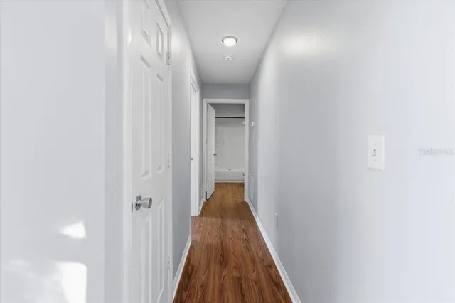 a view of a hallway with wooden floor