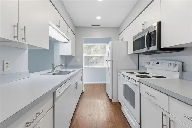 a kitchen with stainless steel appliances granite countertop a sink and a stove top oven