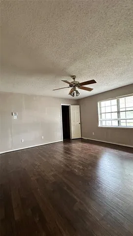 a view of a room with wooden floor and window