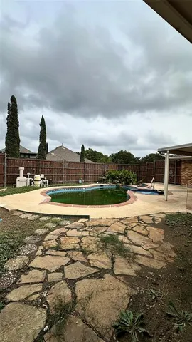 a view of a swimming pool with a patio and a yard