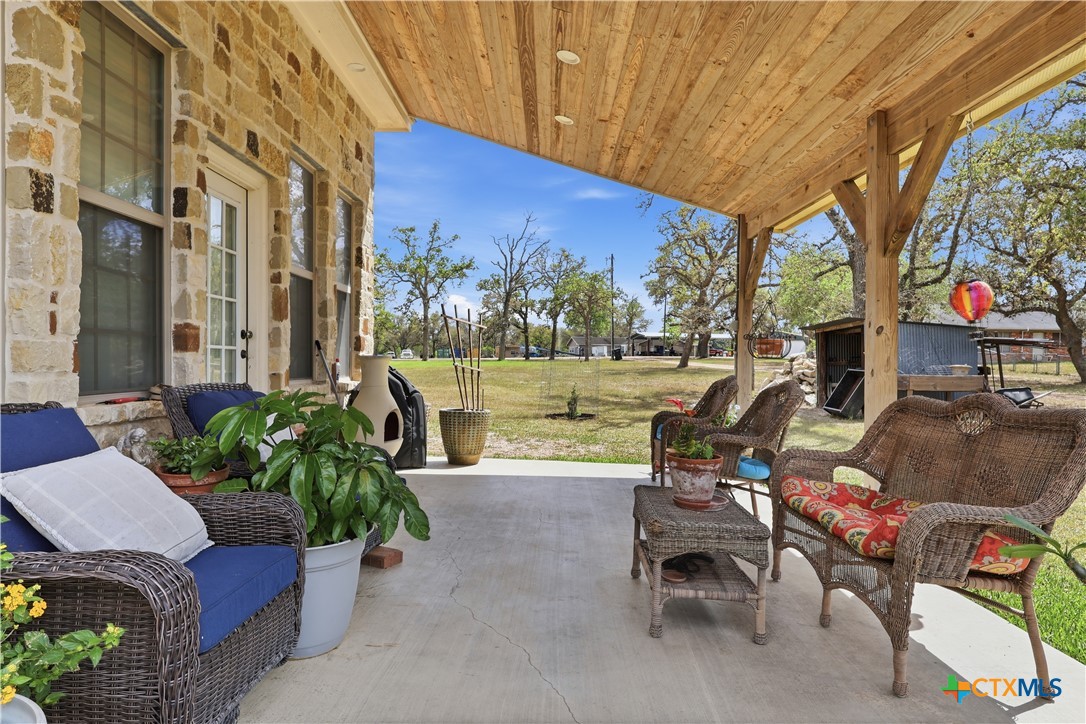 790 Spanish Grant Road Goliad, TX 77963 - Photo 32 of 41 a view of a patio with couches and table and chairs and potted plants