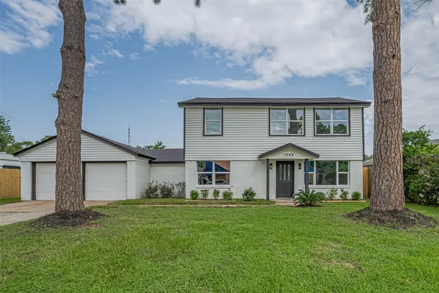a front view of a house with a yard and trees