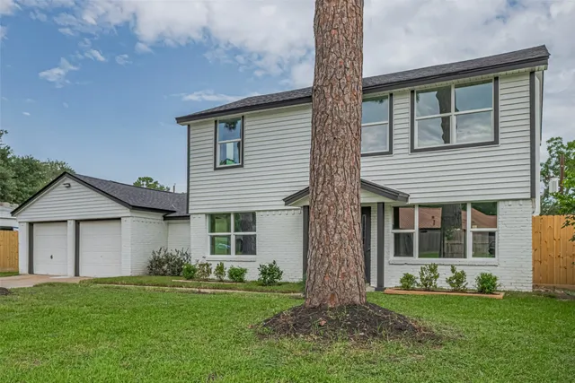 a front view of a house with a garden and yard