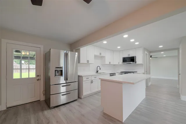 a kitchen with stainless steel appliances a refrigerator sink and microwave