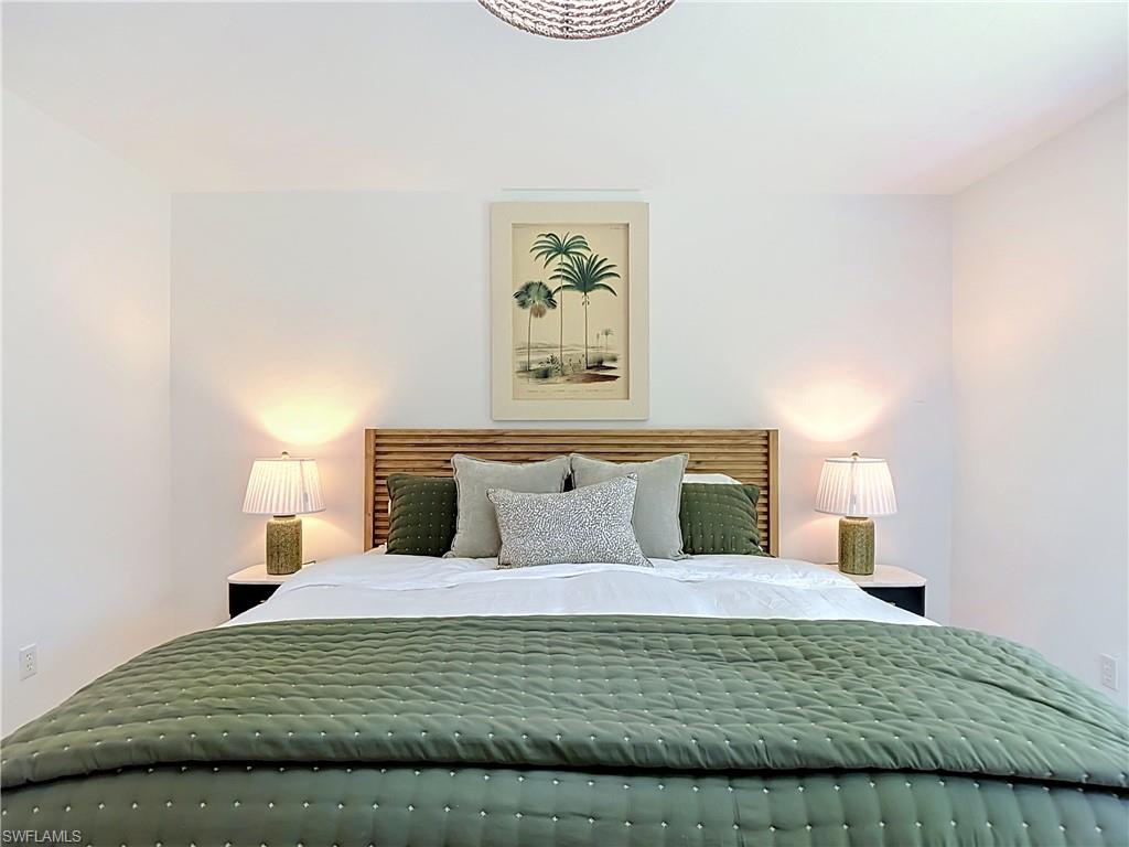 812 102nd Avenue North Naples, FL 34108 - Photo 18 of 33 White painted walls, wood panel headboard, and a built-in ceiling light fixture